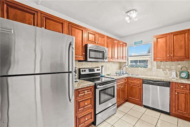 14300 S Padre Island Dr S Unit 220C, Corpus Christi, TX 78418 - kitchen with stainless steel appliances, light tile patterned flooring, brown cabinets, and backsplash