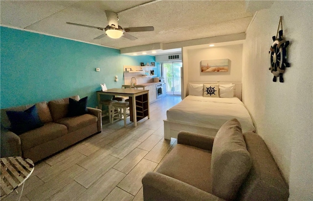 bedroom with sink, a textured ceiling, and ceiling fan