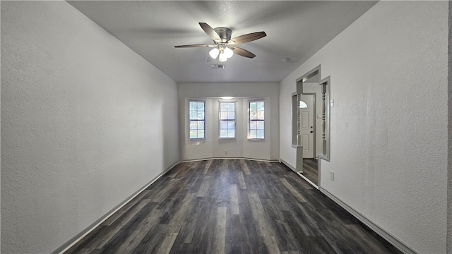 unfurnished room with ceiling fan and dark wood-type flooring