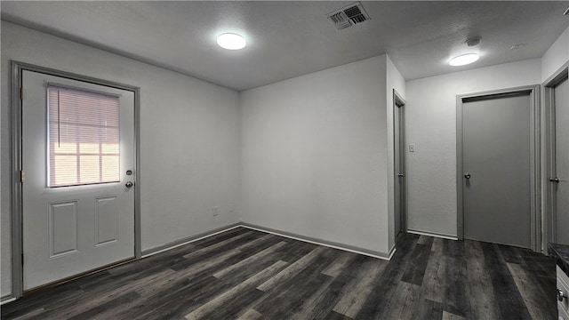 foyer with a textured ceiling and dark hardwood / wood-style flooring