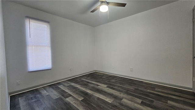 empty room with a ceiling fan, dark wood finished floors, and baseboards