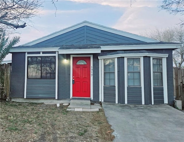 view of front of house with brick siding and fence