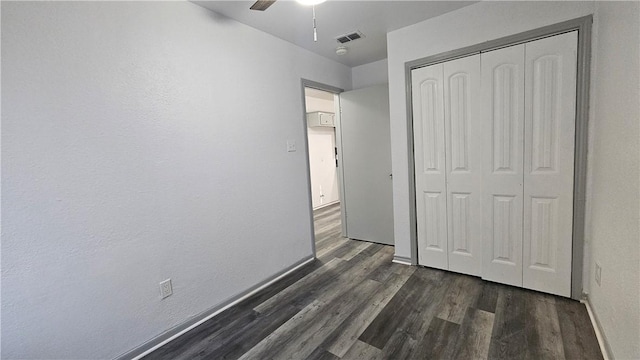 unfurnished bedroom featuring baseboards, visible vents, a ceiling fan, dark wood-style flooring, and a closet