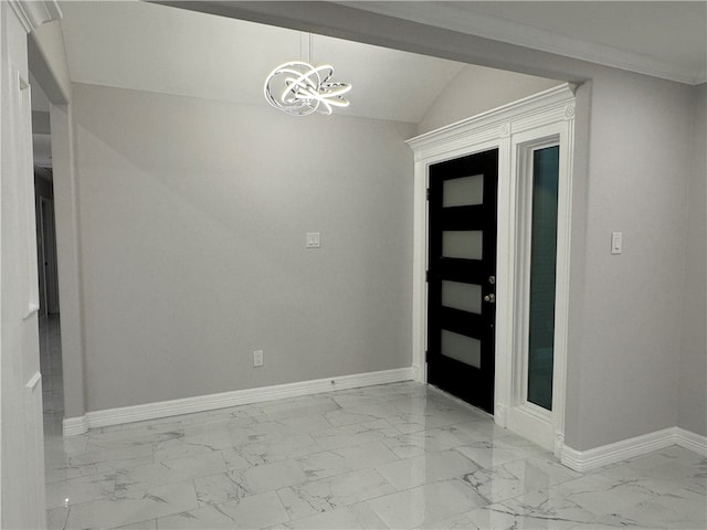 foyer entrance with a chandelier, vaulted ceiling, and ornamental molding