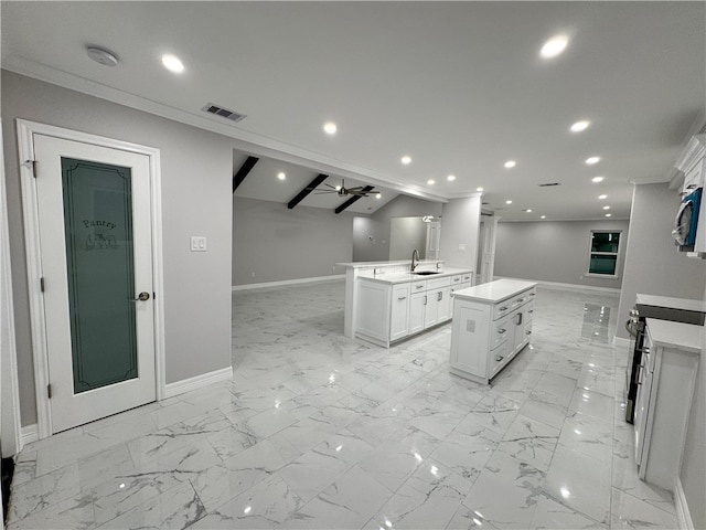 kitchen with ceiling fan, a kitchen island with sink, sink, lofted ceiling with beams, and white cabinetry