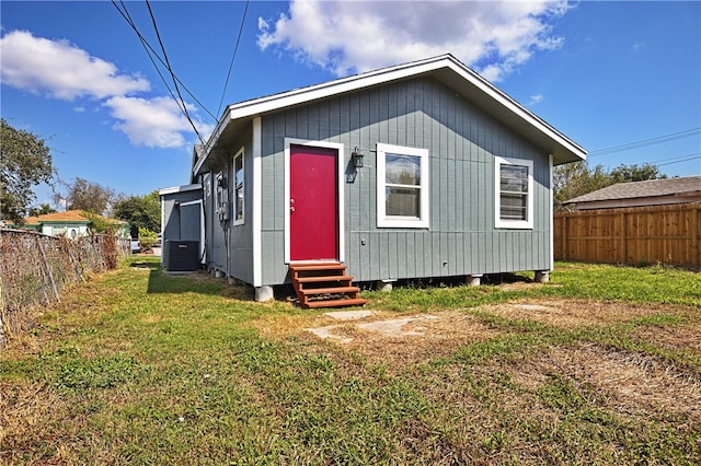 exterior space featuring central air condition unit and a front yard