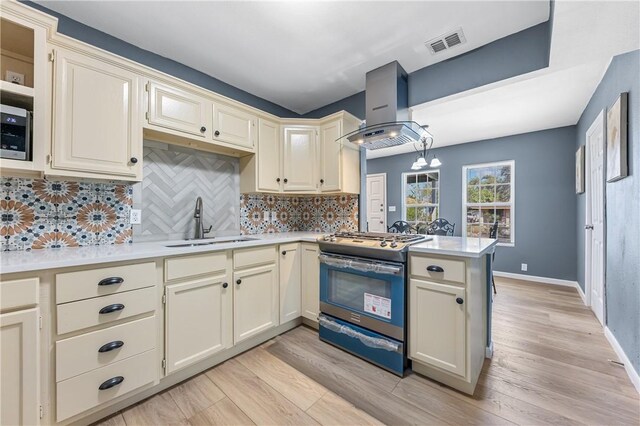 3609 Stinson St, Corpus Christi, TX 78405 - kitchen featuring wall chimney range hood, gas range, a sink, light countertops, and a peninsula