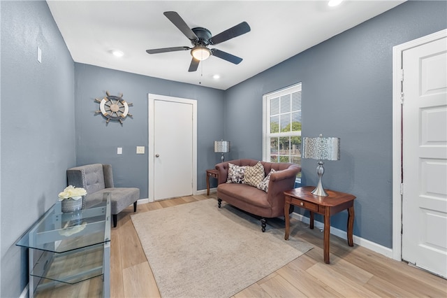 sitting room with ceiling fan and light wood-type flooring