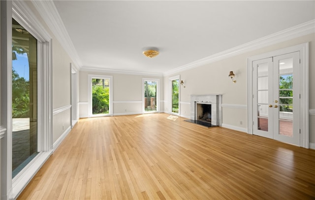 unfurnished living room featuring ornamental molding, french doors, and light hardwood / wood-style flooring