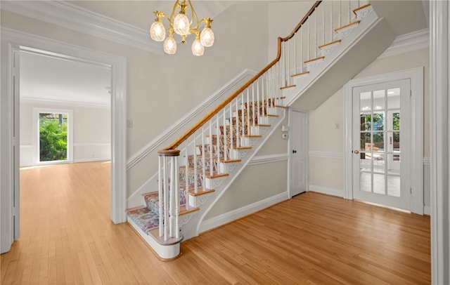 stairway featuring hardwood / wood-style floors, a notable chandelier, and crown molding