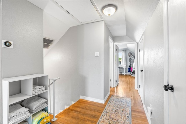 5830 Woodhaven Dr, Corpus Christi, TX 78412 - corridor with vaulted ceiling, light wood finished floors, a textured wall, and an upstairs landing