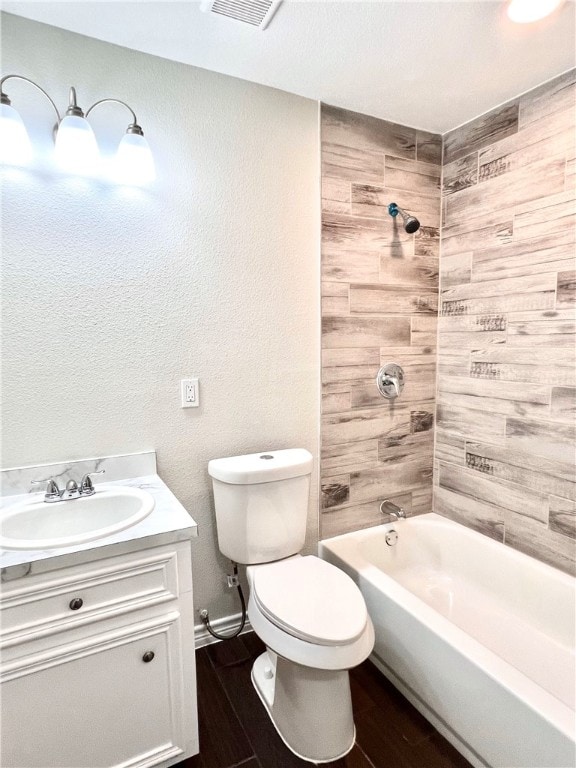 full bathroom featuring toilet, vanity, tiled shower / bath, and wood-type flooring