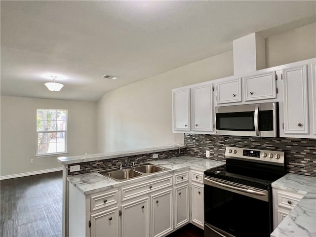 kitchen with white cabinets, sink, kitchen peninsula, and appliances with stainless steel finishes