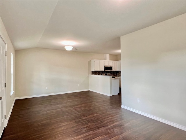 unfurnished living room featuring dark wood-type flooring and lofted ceiling