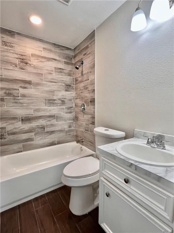 1652 16th St, Corpus Christi, TX 78404 - full bathroom featuring shower / bath combination, toilet, vanity, wood finish floors, and a textured wall