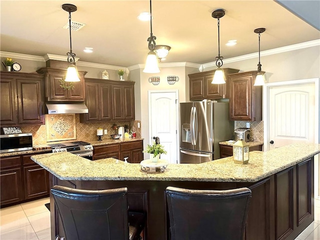 kitchen featuring hanging light fixtures, a kitchen bar, and appliances with stainless steel finishes