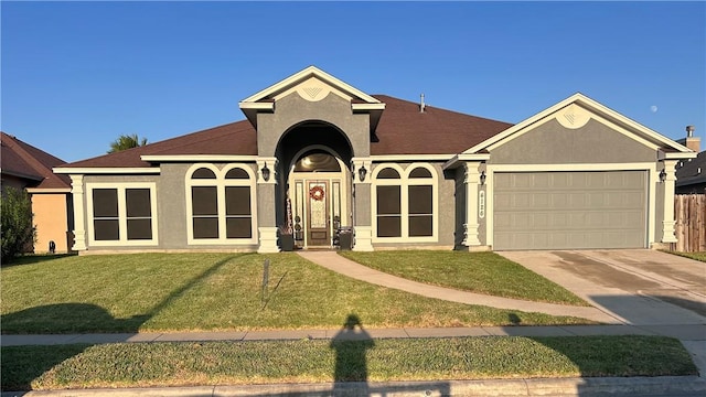 ranch-style house featuring a garage and a front lawn