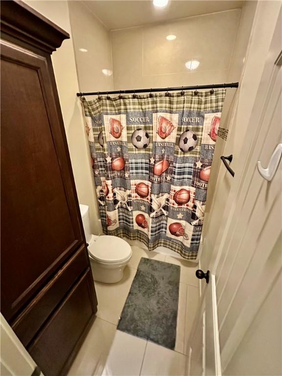 bathroom with walk in shower, tile patterned floors, and toilet