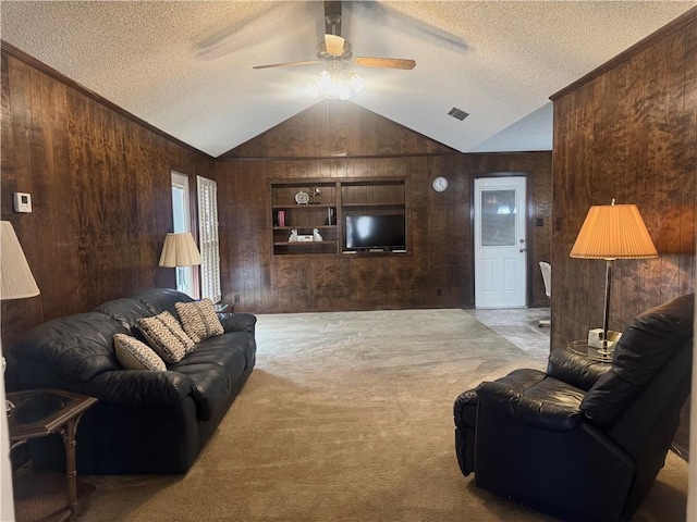 carpeted living room featuring a textured ceiling, built in features, and wooden walls