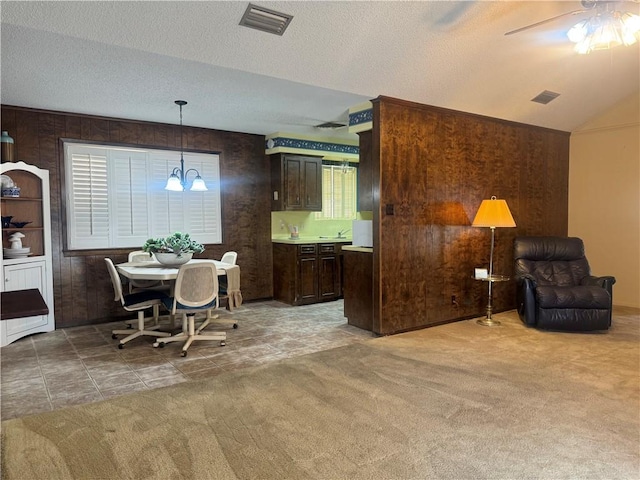 interior space with lofted ceiling, a textured ceiling, and visible vents