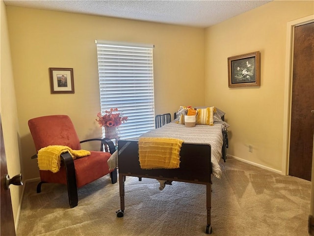 bedroom with a textured ceiling, carpet flooring, and baseboards