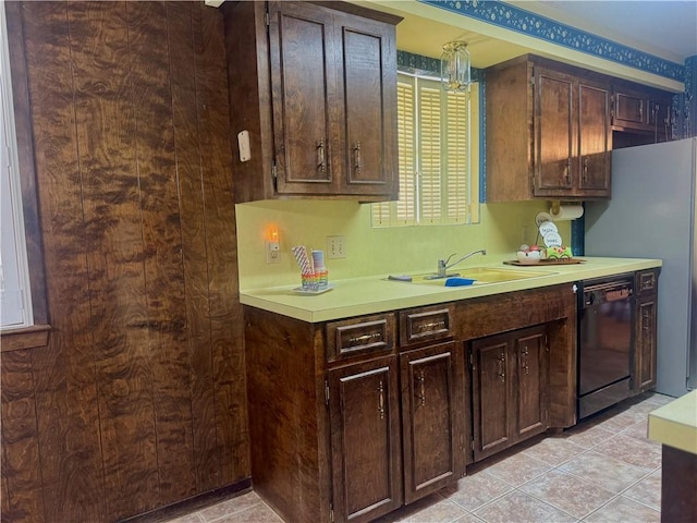 kitchen featuring dark brown cabinetry, black dishwasher, light tile patterned floors, light countertops, and a sink