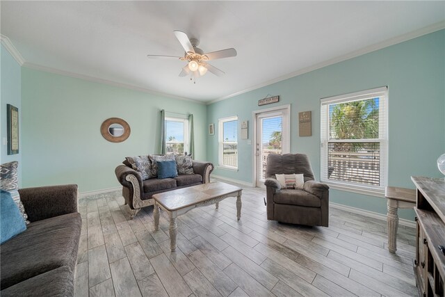 living room with ornamental molding, light hardwood / wood-style floors, and ceiling fan