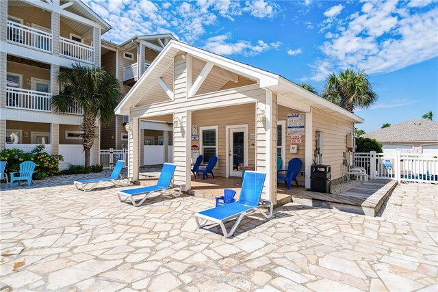 rear view of property featuring a patio area and a balcony