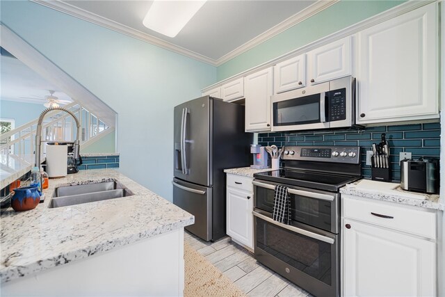 kitchen featuring decorative backsplash, sink, crown molding, white cabinetry, and appliances with stainless steel finishes