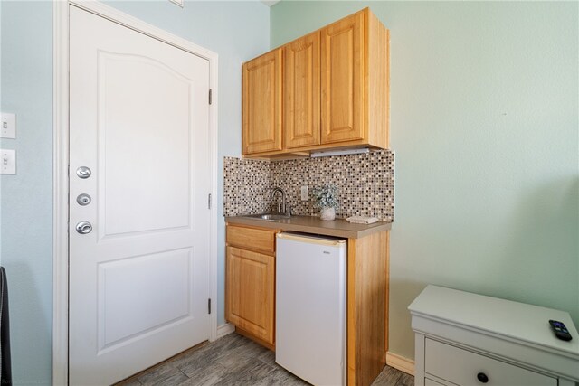 kitchen featuring light hardwood / wood-style flooring, sink, white appliances, and backsplash