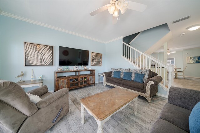 living room featuring ornamental molding, light wood-type flooring, and ceiling fan