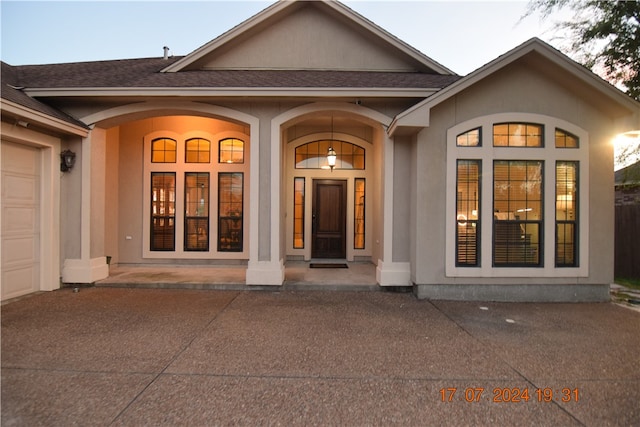 exterior entry at dusk featuring a garage