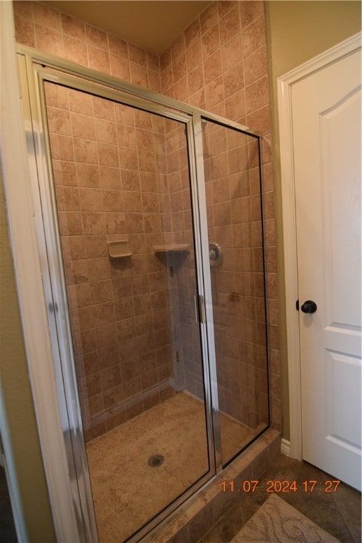 bathroom featuring a shower with shower door