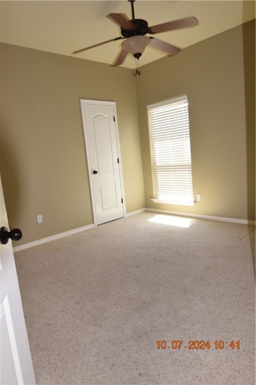 carpeted empty room featuring ceiling fan