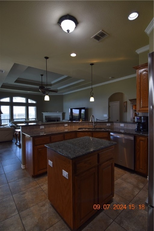 kitchen with stainless steel dishwasher, ornamental molding, sink, and a center island