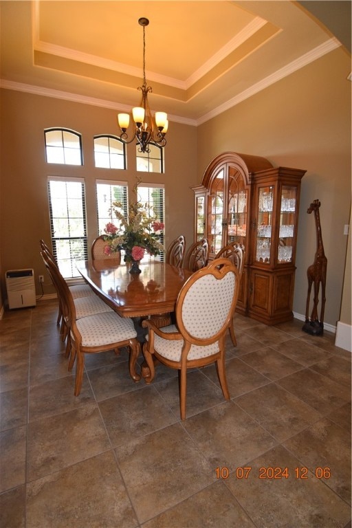 dining room with crown molding, a tray ceiling, and an inviting chandelier