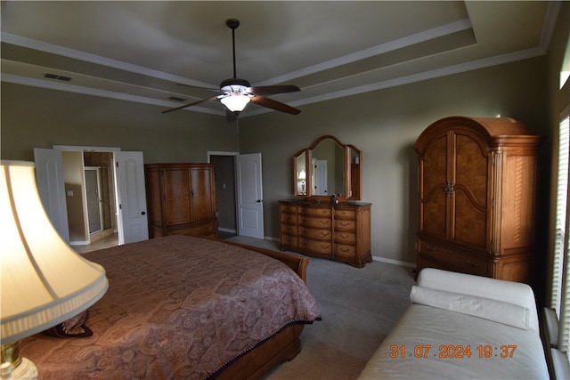 carpeted bedroom featuring ceiling fan, crown molding, and a tray ceiling