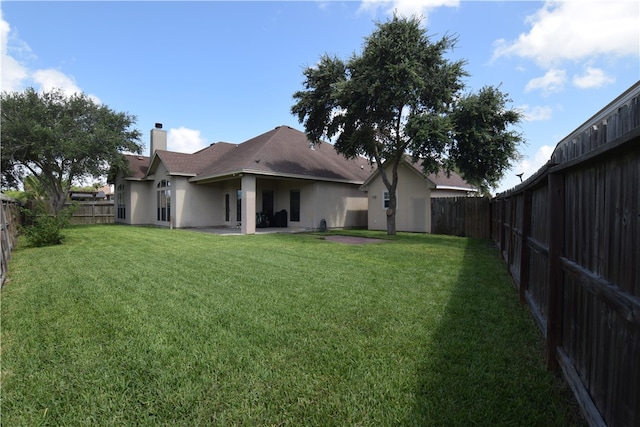 back of house featuring a lawn and a patio