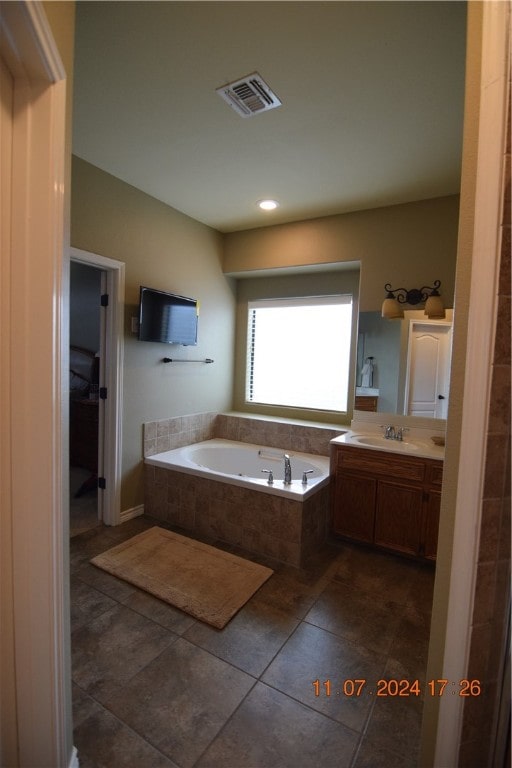 bathroom featuring vanity, tiled bath, and tile patterned flooring