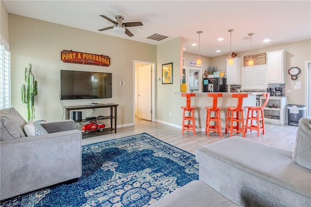 living area featuring baseboards, visible vents, a ceiling fan, light wood-type flooring, and recessed lighting