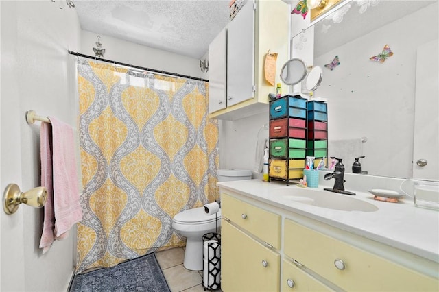 bathroom featuring tile patterned floors, toilet, a textured ceiling, and vanity