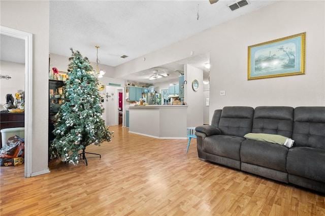 living room with light hardwood / wood-style flooring and ceiling fan