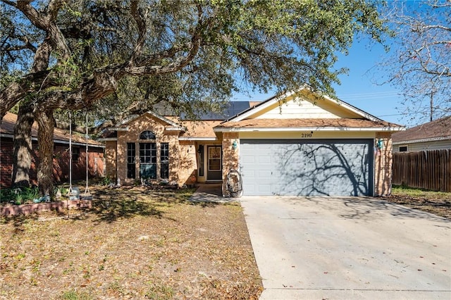 ranch-style house featuring a garage and solar panels