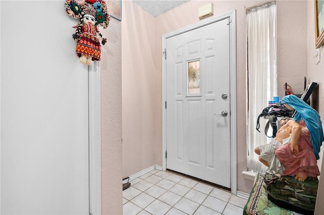 doorway to outside with a textured ceiling and light tile patterned floors