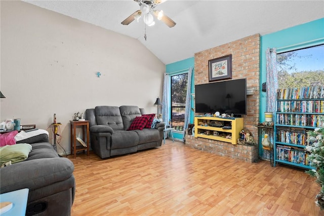 living room with lofted ceiling, light hardwood / wood-style floors, and a wealth of natural light