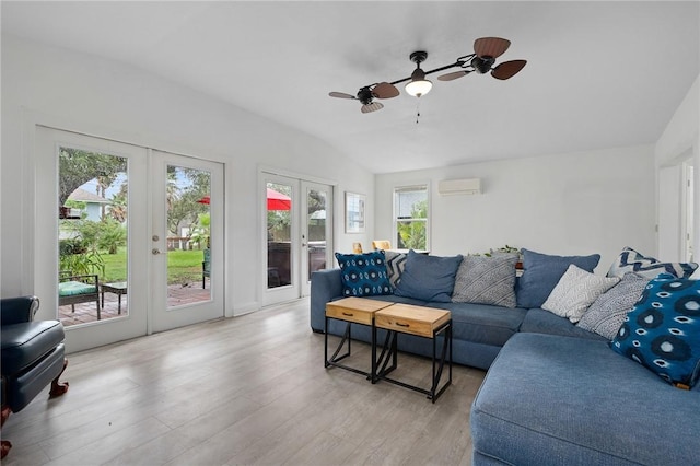 living room featuring french doors, a wall unit AC, ceiling fan, light hardwood / wood-style floors, and lofted ceiling