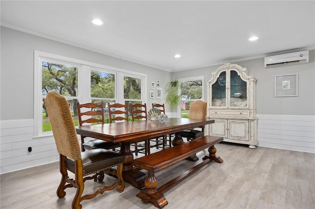 dining room featuring light hardwood / wood-style floors, an AC wall unit, ornamental molding, and wooden walls