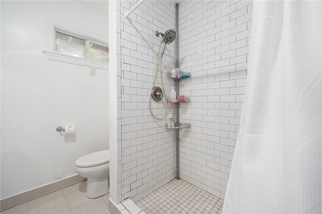 bathroom with tile patterned floors, toilet, and walk in shower