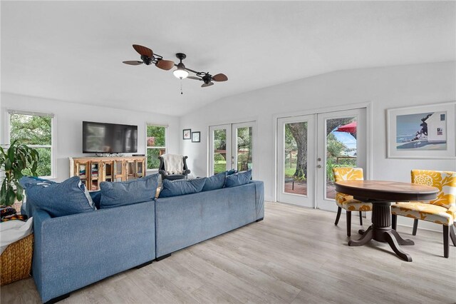 living room with ceiling fan, french doors, a healthy amount of sunlight, and vaulted ceiling