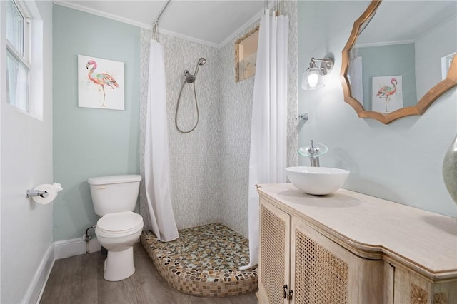 bathroom featuring hardwood / wood-style floors, vanity, crown molding, toilet, and curtained shower